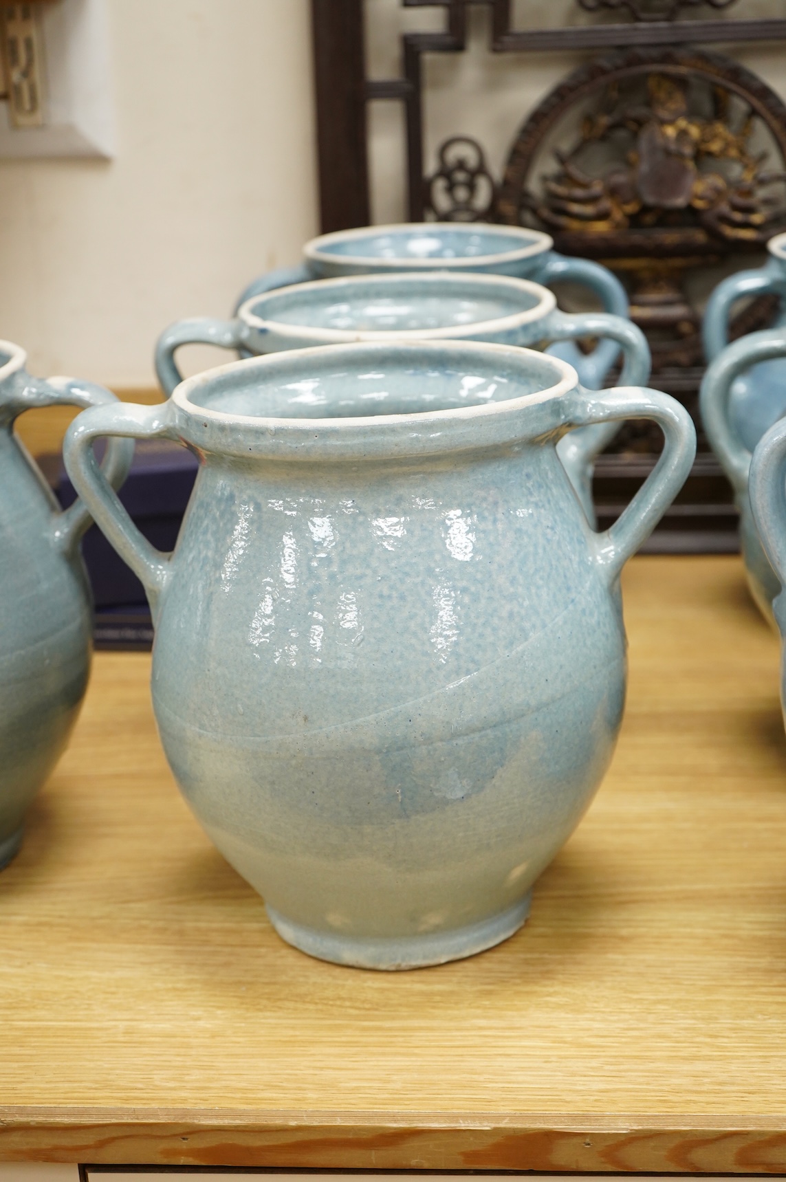 Seven early 20th century Continental blue glazed terracotta twin handled jars, 26cm high